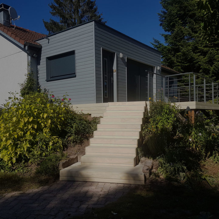 Extension de maison en bois gris avec des escaliers en bois Accoya à Champagney dans le 70